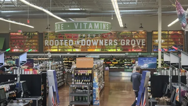 Inside a Fresh Thyme Grocery store, looking at the location's self-checkout stations and produce section