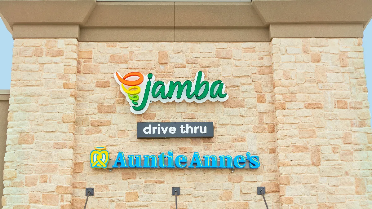 An exterior shot of a beige brick building with the words "Jamba," "drive-thru" and "Auntie Anne's."