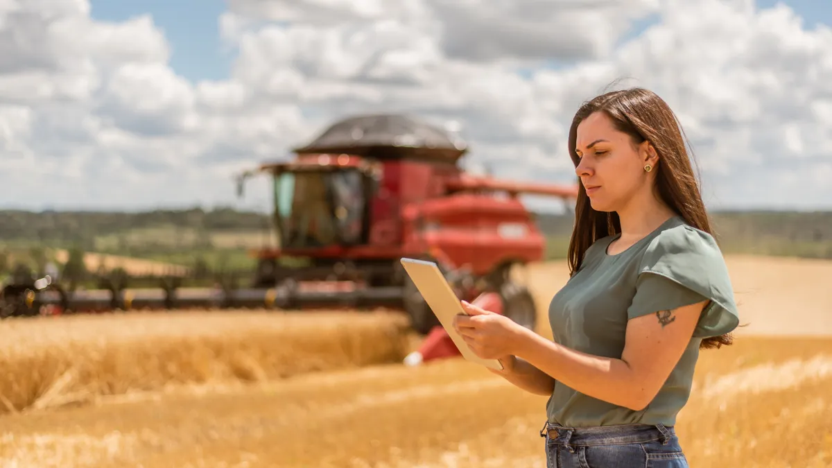 Agronomist woman using digital tablet in wheat field.