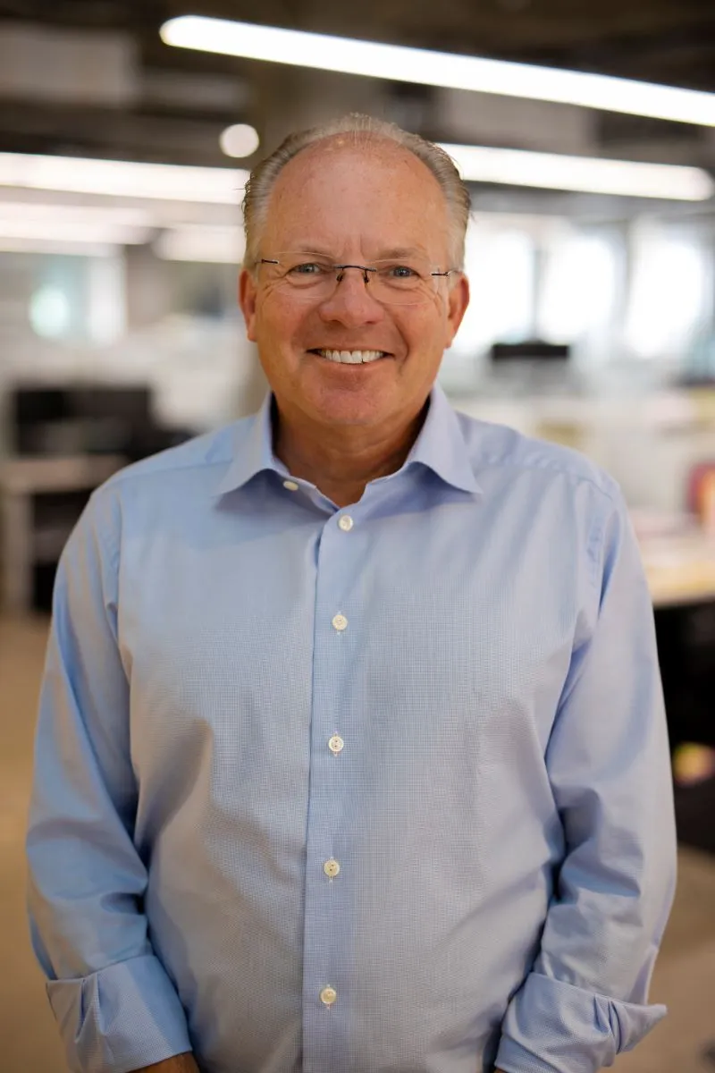 A man wearing a light blue buttoned shirt.