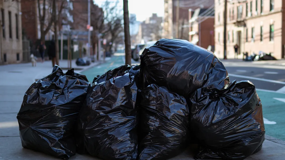 Black trash bags on a sidewalk in New York City