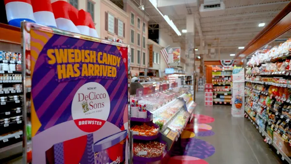 An aisle in a grocery store with a sign that reads "Swedish Candy has Arrived" in capital letters at the left.