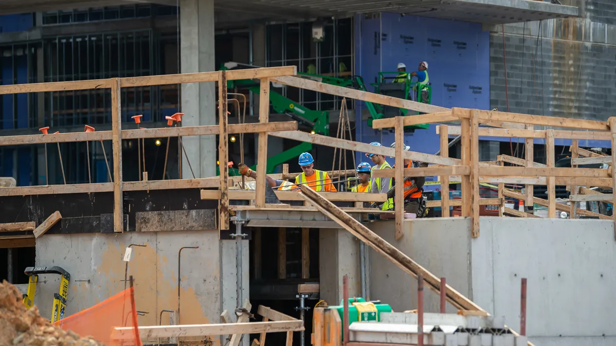 Construction workers perform jobs at a building site.