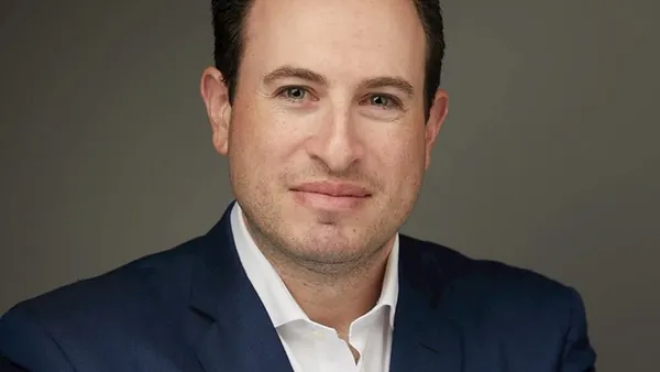 Pictured is a man in a suit