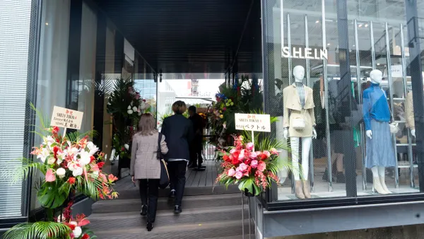 Two people walk up steps to a Shein store.