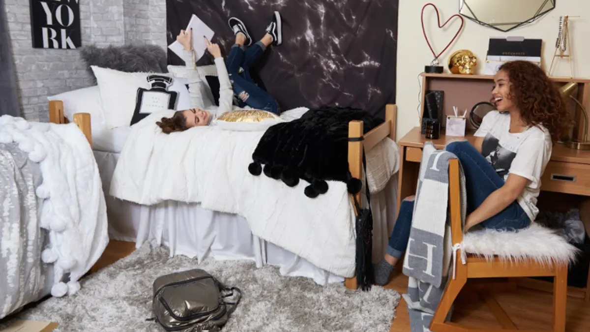 Two people sitting in a dorm room