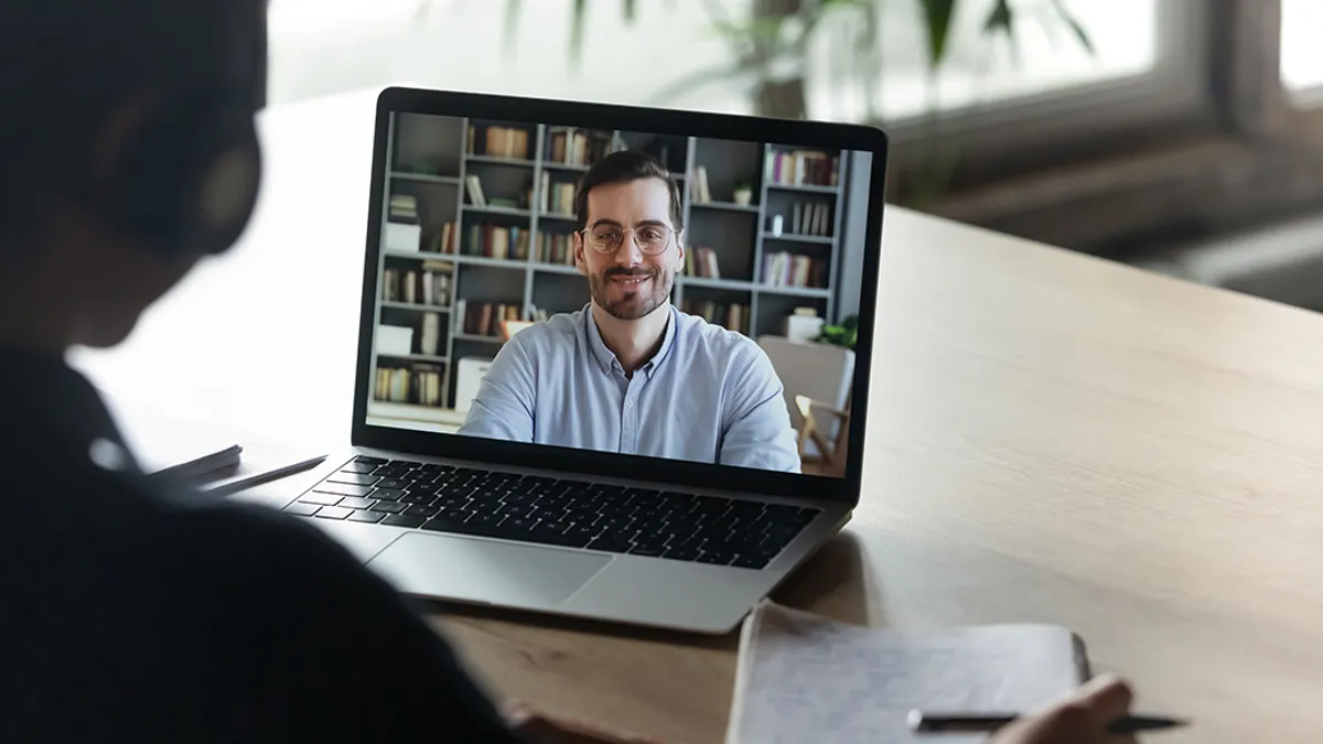 Colleagues working distantly using video call and computer.