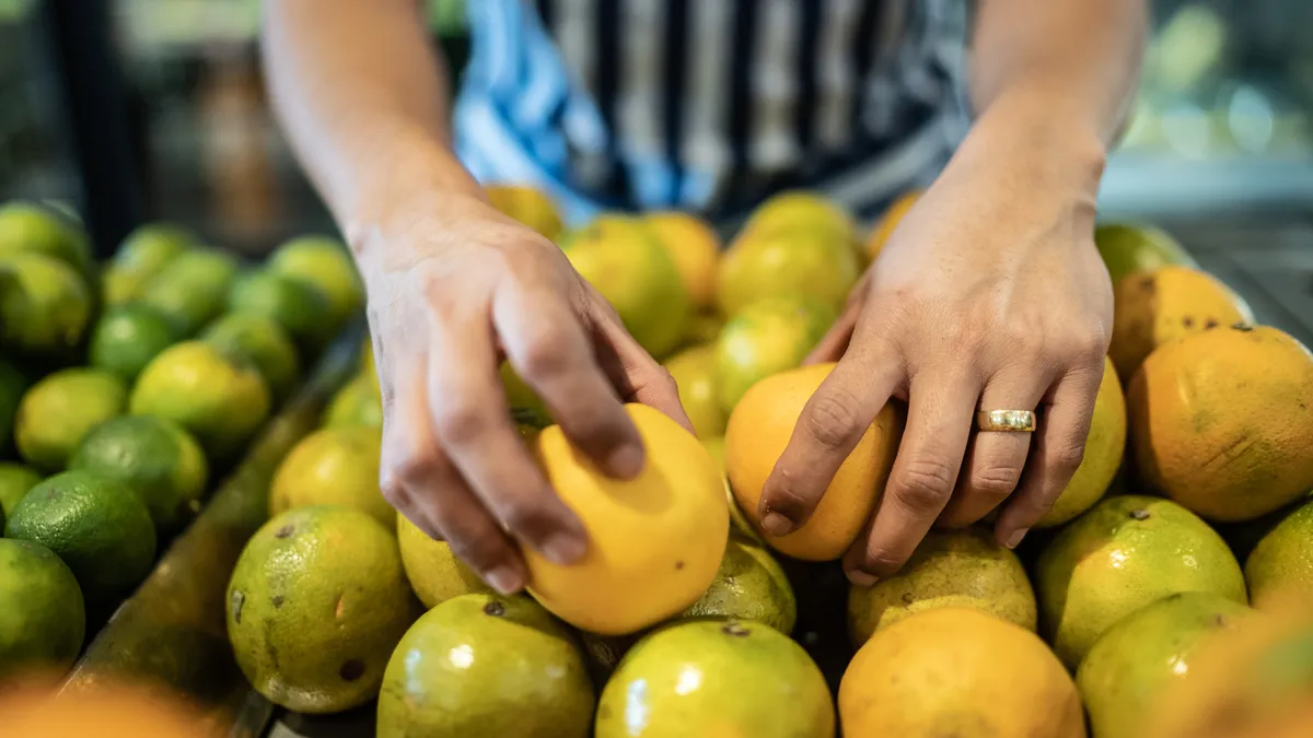 Hands arrange fruits in a market