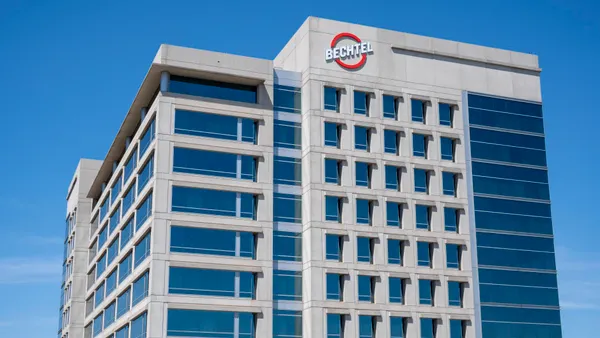 A large gray-ish stone building looms in the foreground. A red circle with the name "Bechtel" is emblazoned on the structure.