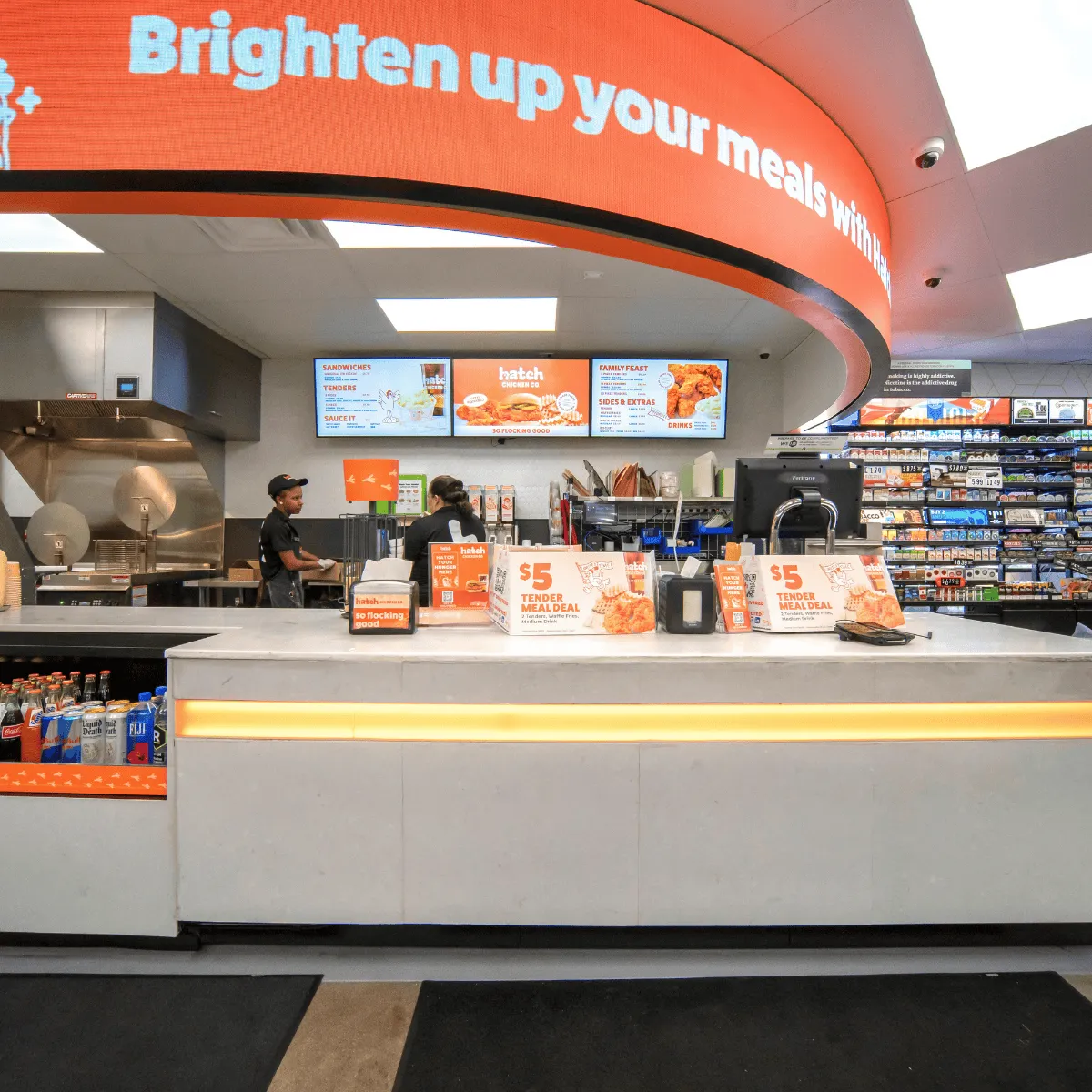 A photo of the interior of a convenience store, looking at a foodservice counter. A sign over the counter says &quot;Brighten up your meals with Hatch.&quot;