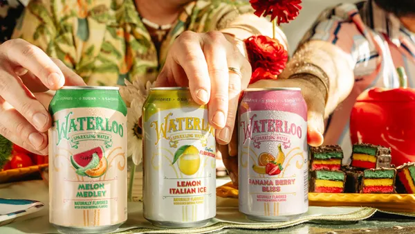People reach for a trio of Waterloo Sparkling Water cans sitting on a countertop