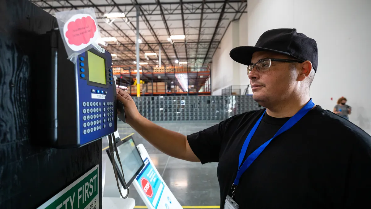 An employee uses a card to clock in for a shift.