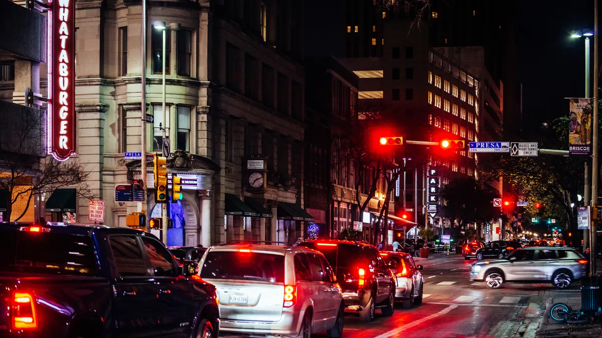 Cars line up at a red light in a city.