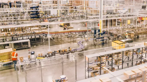 Torani's food manufacturing facility, one person wearing a safety vest walks on the left