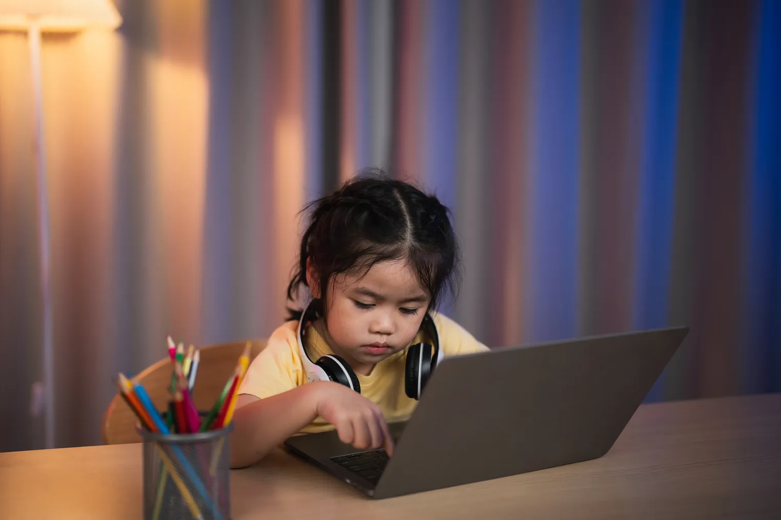 A young child uses a laptop computer at home.