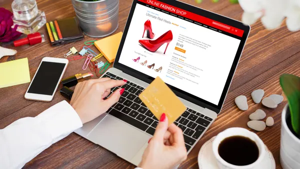 Woman ordering new high heel shoes in online shop and paying for purchase by credit card.