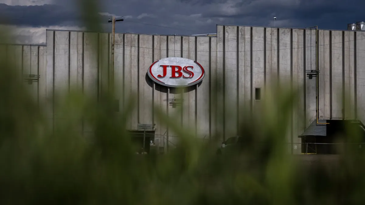 The outside of a building is seen with the JBS logo