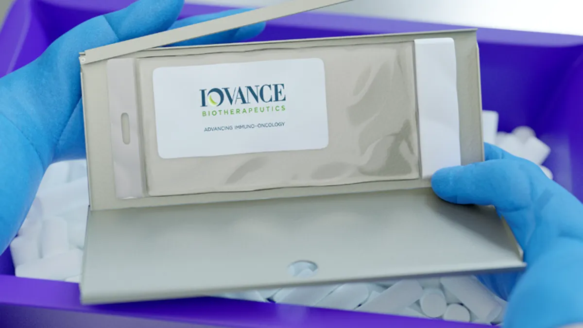 Packaging for Iovance Biotherapeutics' cellular medicine Amtagvi is held by a technician wearing gloves.