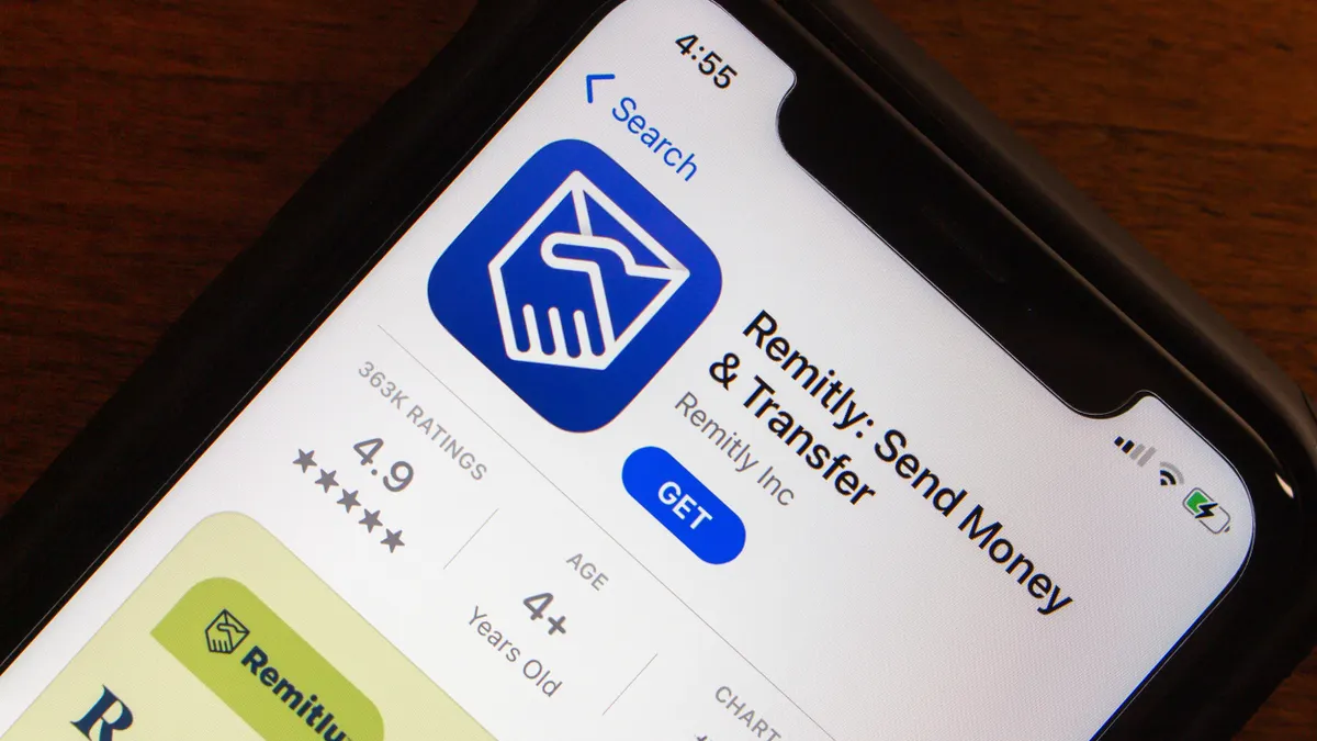 ​A close-up of an iPhone screen displaying the Remitly: Send Money & Transfer app's listing in the Apple App Store. The screen shows the Remitly logo, app name, and download option, highlighting the digital remittance service's presence on mobile platforms. 