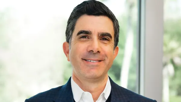 Professional photo of Peter Menziuso, smiling and wearing a blue blazer.