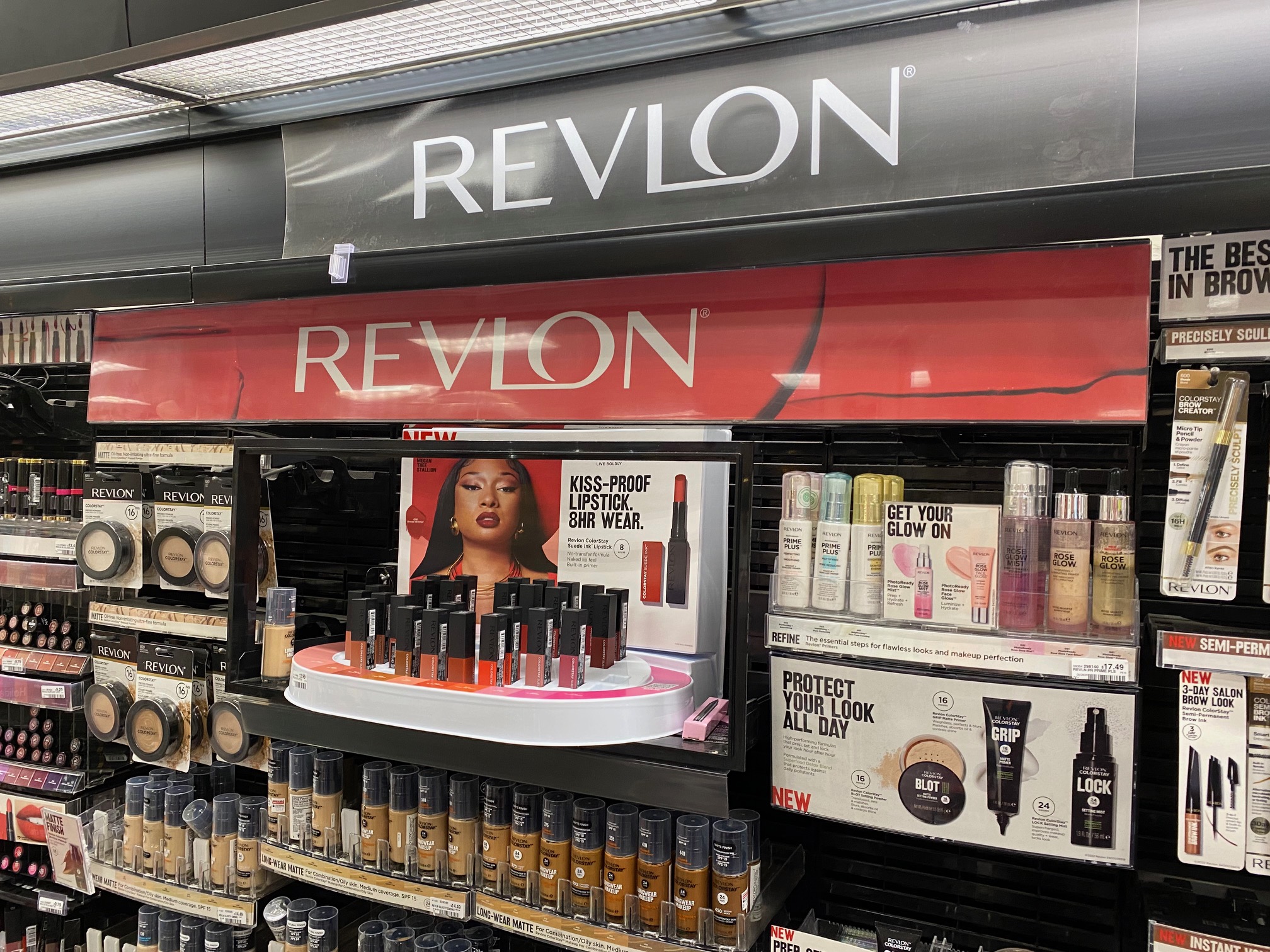 Line up of Revlon products inside of a store with the Revlon sign.