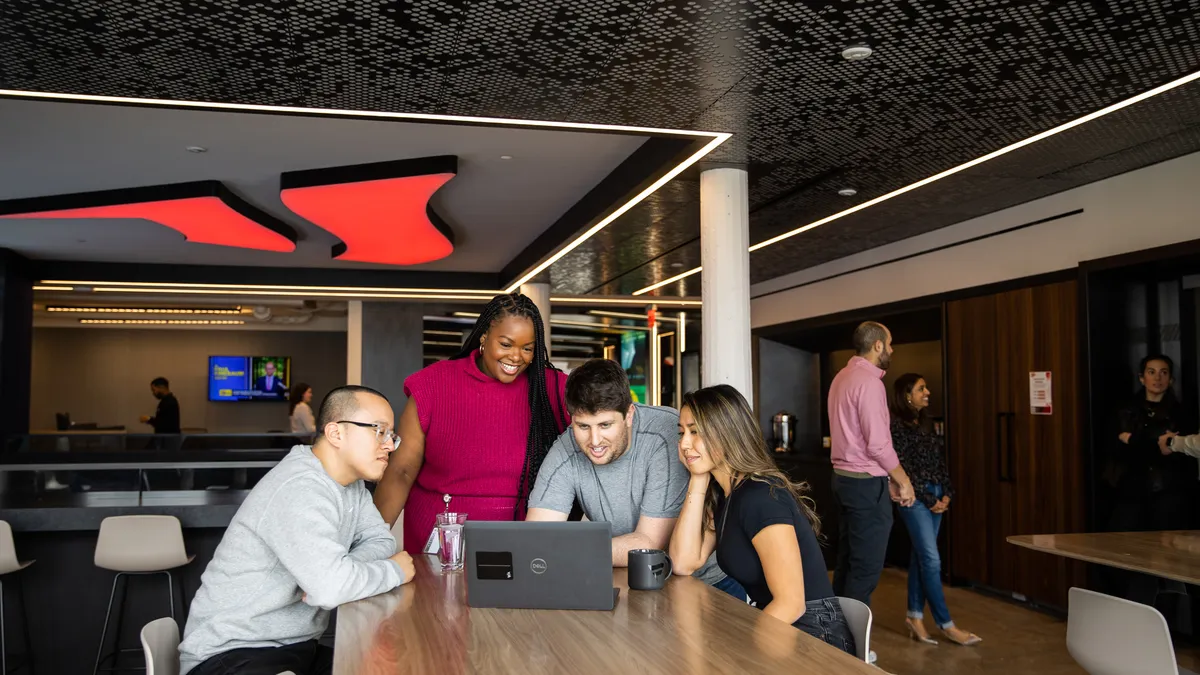 A group of Fanatics employees looks at a laptop screen.