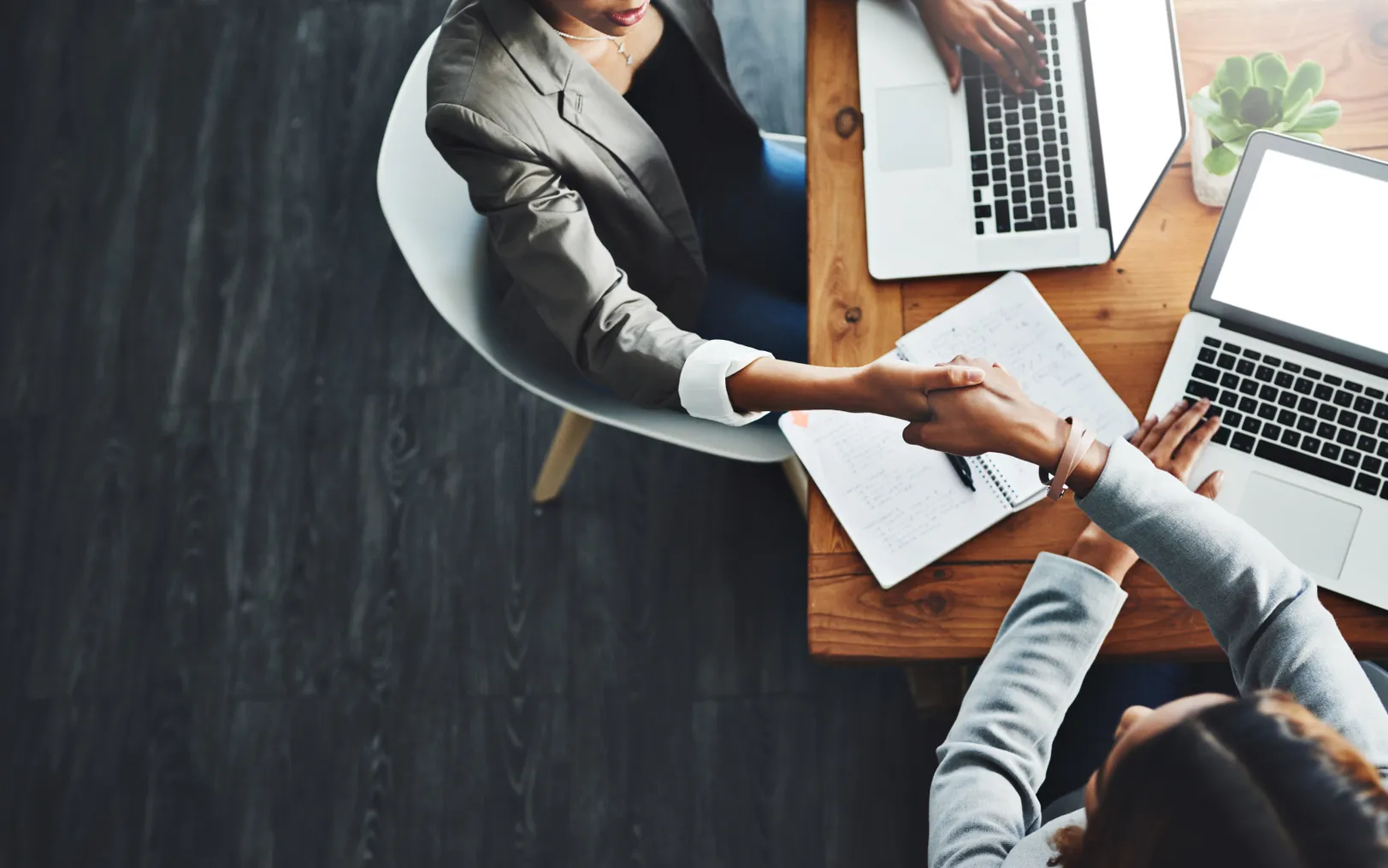 High angle shot of two business people shaking hands in an office