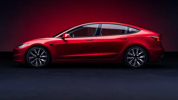 A marketing photo of a 2024 red Tesla model 3 sedan.