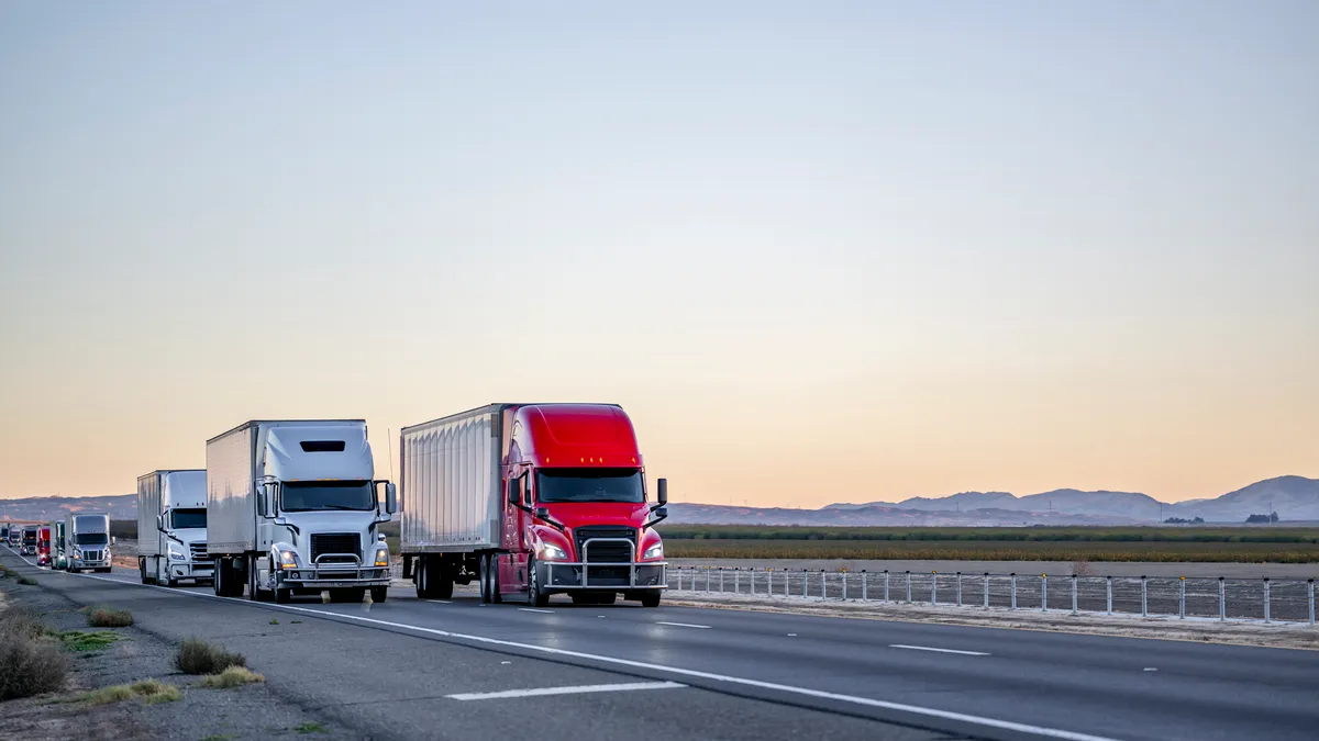 Tractor-trailers driving on a highway road at twilight time in California