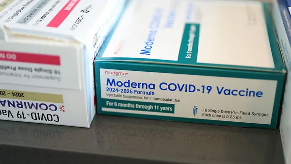 Boxes of Moderna and Pfizer COVID-19 vaccines sit by side in this photo illustration.