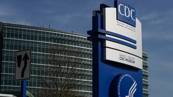 A sign bearing the logo for the Centers for Disease Control and Prevention stands outside of an office building.