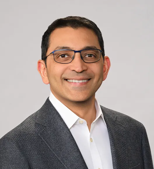 A photo headshot of the CEO of NEOK biotech Mayank Gandhi against a gray background