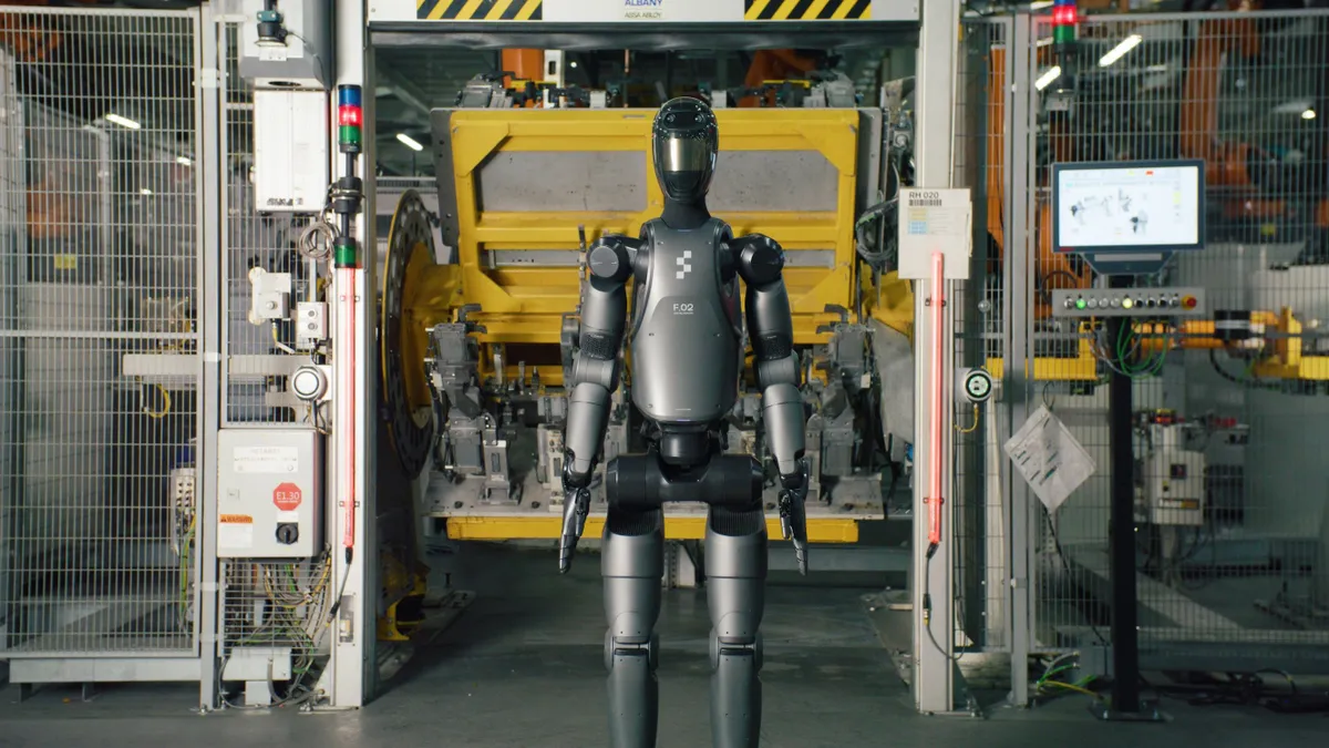 The Figure 02 humanoid robot shown inside BMW's Plant Spartanburg production facility with machinery in the background.