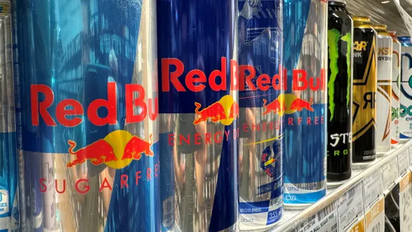 Red Bull cans are displayed next to each other on a store shelf.