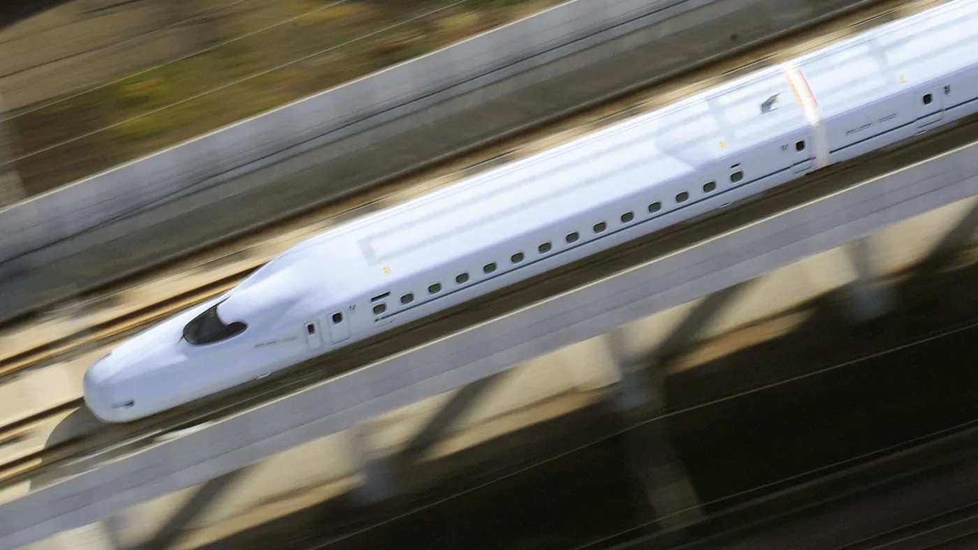 Aerial view of white bullet train in motion.