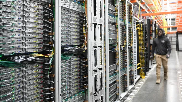 Amazon worker walks inside a data center facility