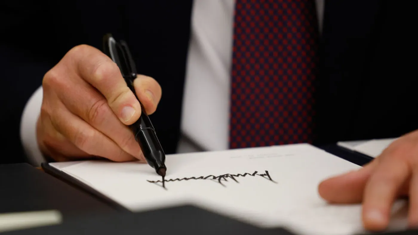 Trump holds up a signed execuitve order