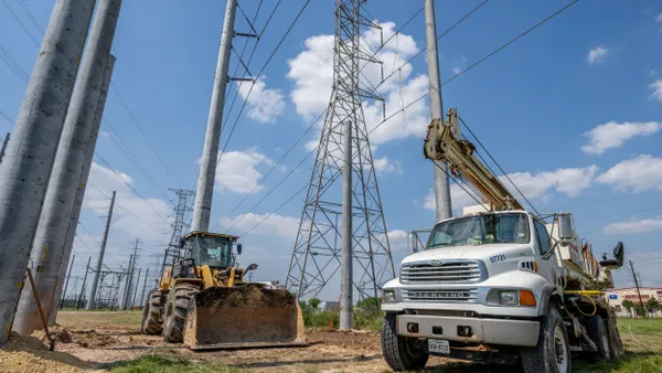 Construction equipment is stationed near transmission towers.