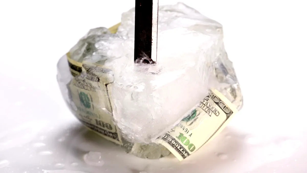 Breaking ice frozen with $100 bill.