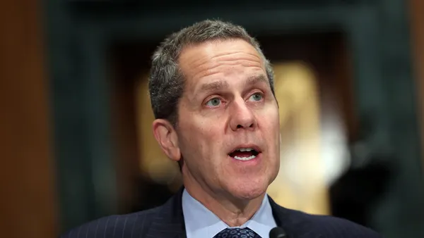 Federal Reserve Gov. Michael Barr speaks into a microphone during a congressional hearing.