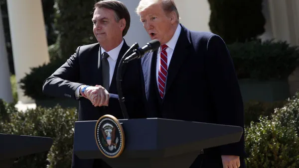President Donald Trump and Brazilian President Jair Bolsonaro shaking hands at a joint news conference.