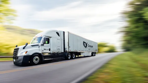A moving freight truck on the road with a blurred background.