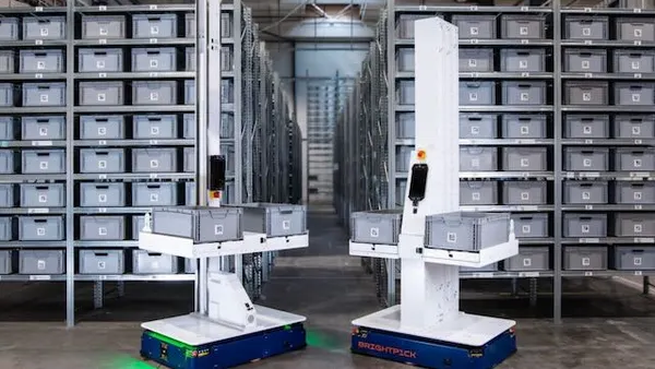Brightpick robots standing in front of metal racks in a facility.
