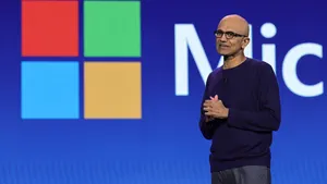 CEO Satya Nadella of Microsoft pictured on stage with the Microsoft logo in the background.