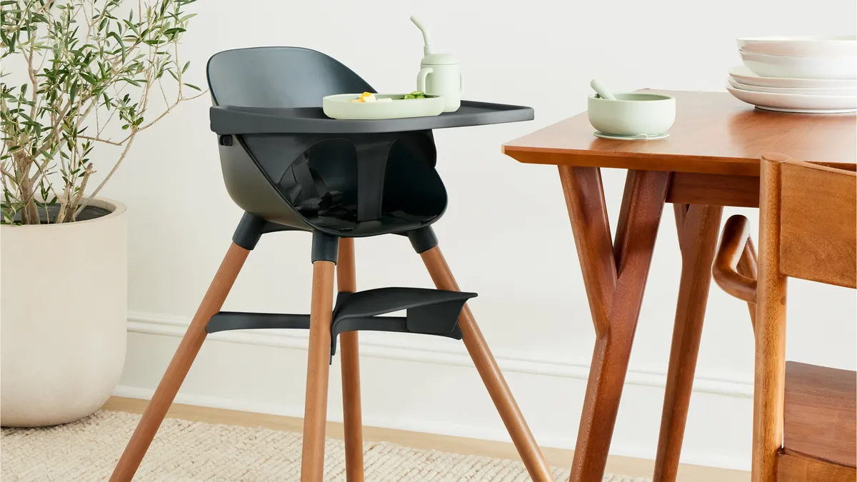 Children's high chair sits next to a table.