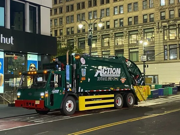 An Action Environmental waste truck driving in New York City