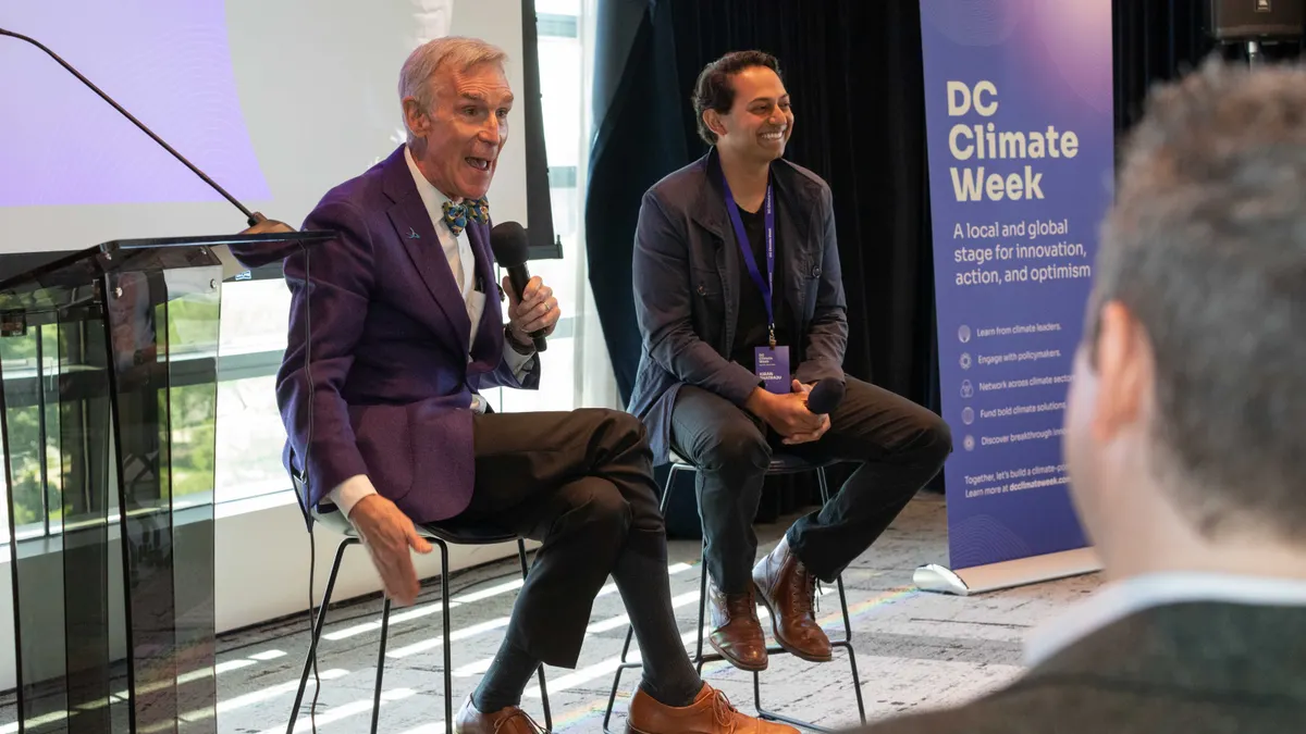 Bill Nye gesturing seated next to Arcadia CEO Kiran Bhatraju with a DC Climate Week sign in the far right of the image.