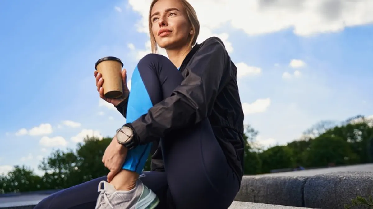 Woman having cup of coffee outdoors