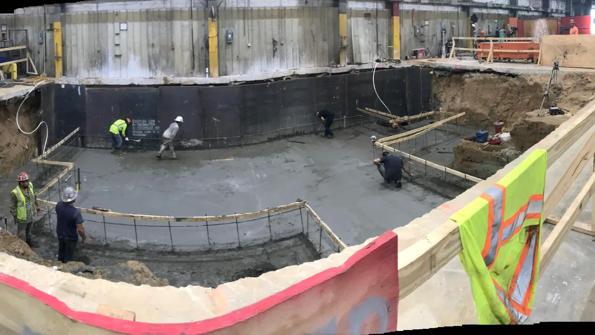 A group of workers purs the foundations of what will be a Correa Axia-70 milling machine at the St. George, South Carolina, facility of sawmill part maker BID Group on  Friday, July 23, 2021.