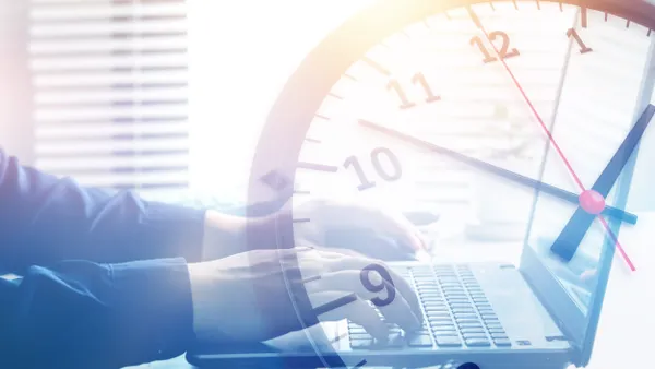 Hands typing on a laptop with clock overlaid on the image.